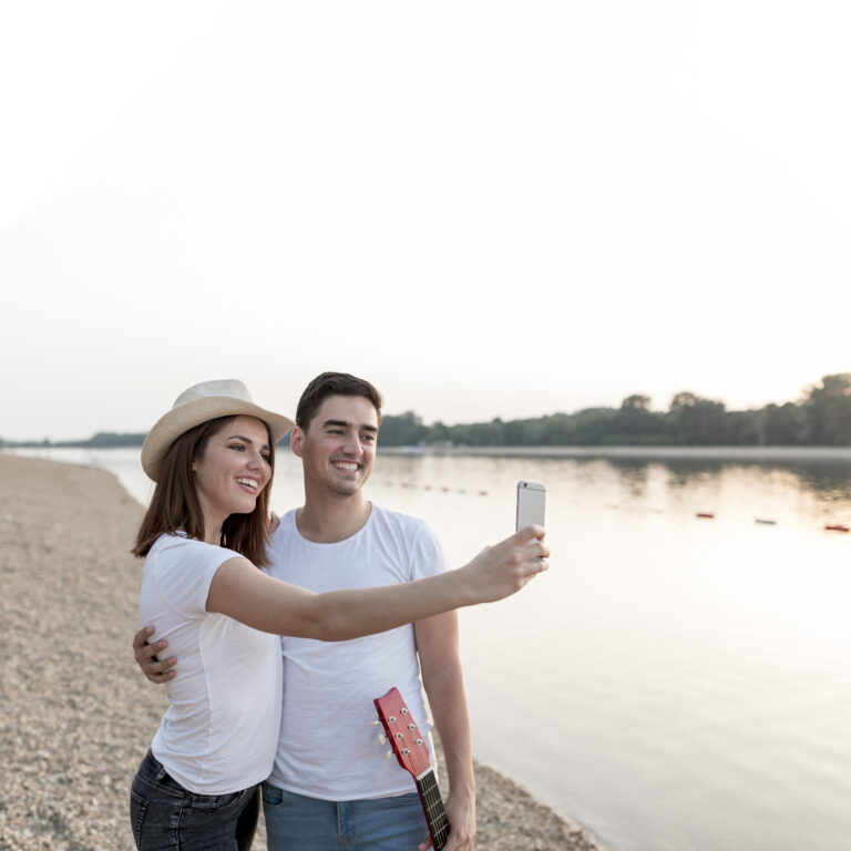 feliz-pareja-joven-tomando-selfies-al-atardecer