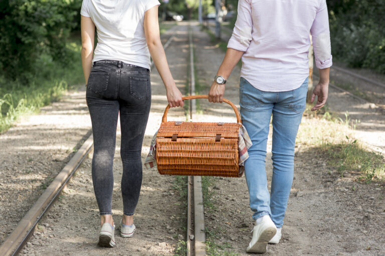 pareja-en-un-ferrocarril-llevando-una-cesta-de-picnic